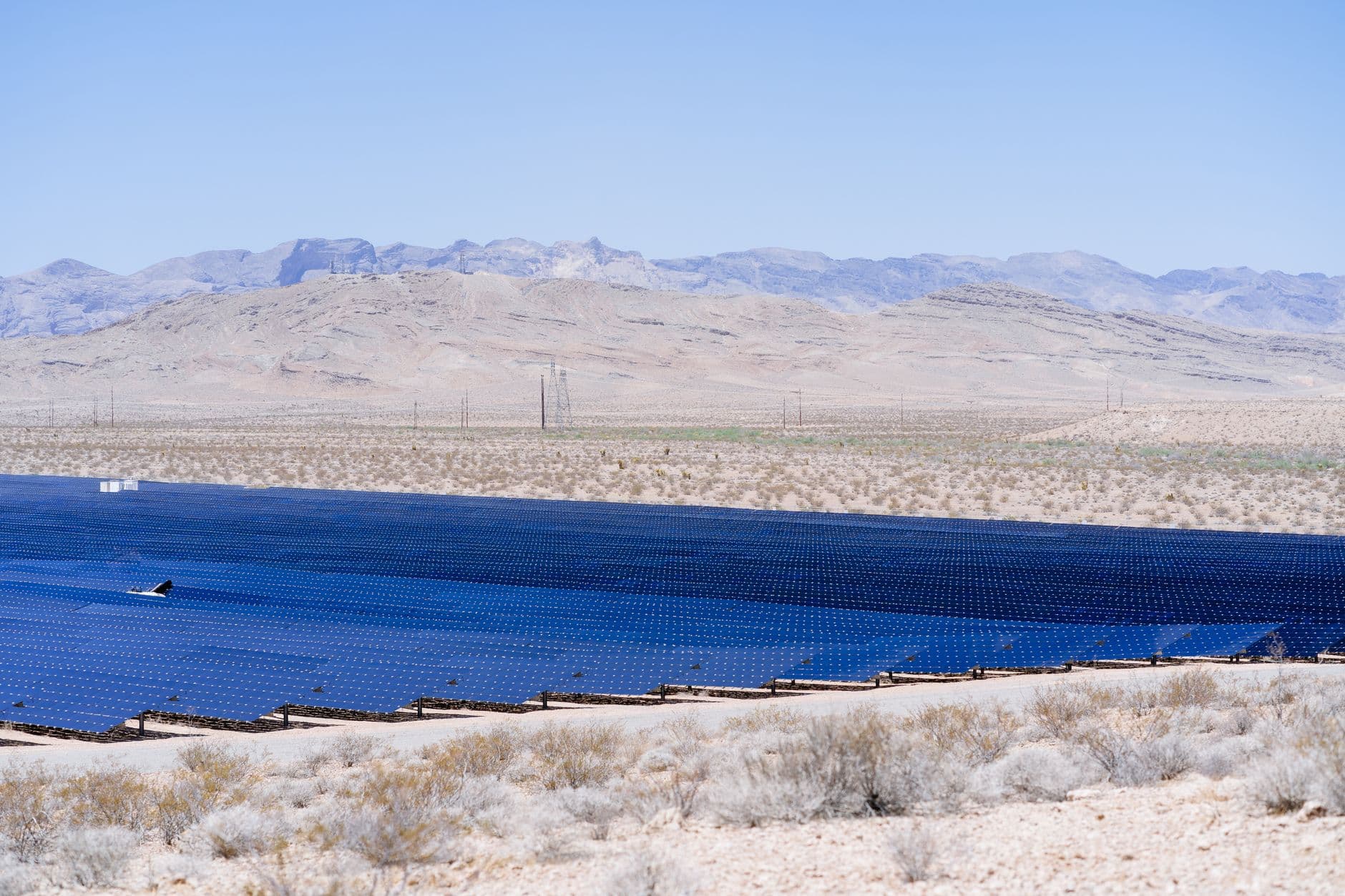 Aerial view of a large solar farm spreading across a desert landscape